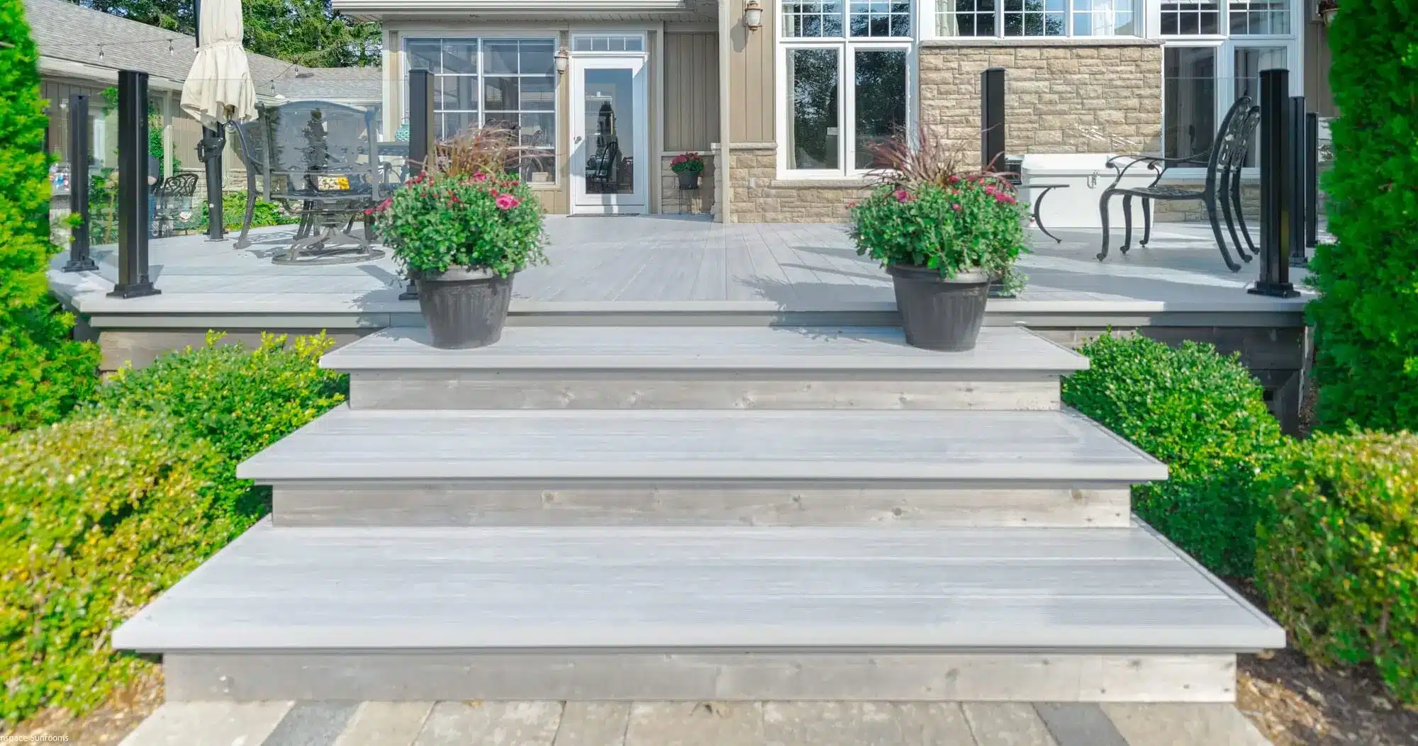 A sleek, grey AlumaDeck aluminum decking system featuring wide planks and a non-slip, powder-coated finish.